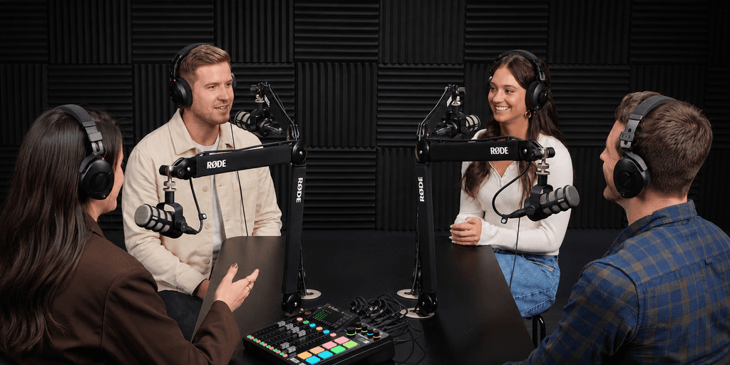 Four people engaging in a podcast recording session with microphones and headphones
