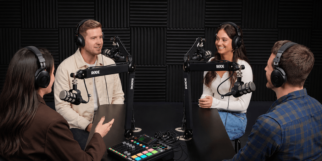 Four people engaging in a podcast recording session with microphones and headphones
