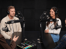 Four people engaging in a podcast recording session with microphones and headphones