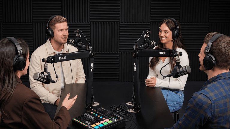 Four people engaging in a podcast recording session with microphones and headphones
