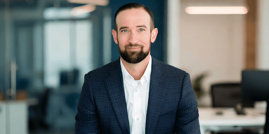 Professional man in a suit sitting in an office environment with modern decor