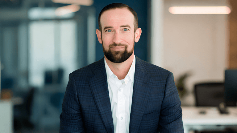 Professional man in a suit sitting in an office environment with modern decor
