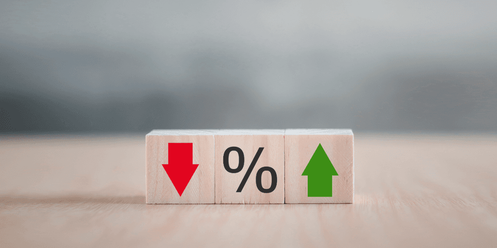 Wooden blocks displaying a red down arrow, percentage sign, and green up arrow