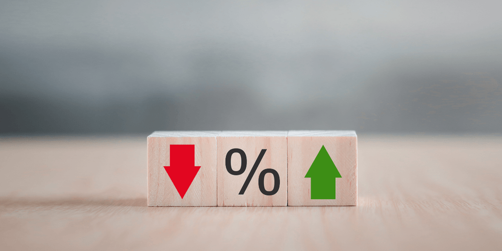 Wooden blocks displaying a red down arrow, percentage sign, and green up arrow
