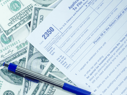 Application form 2350 surrounded by U.S. dollar bills and a blue pen