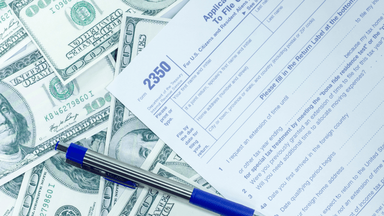 Application form 2350 surrounded by U.S. dollar bills and a blue pen