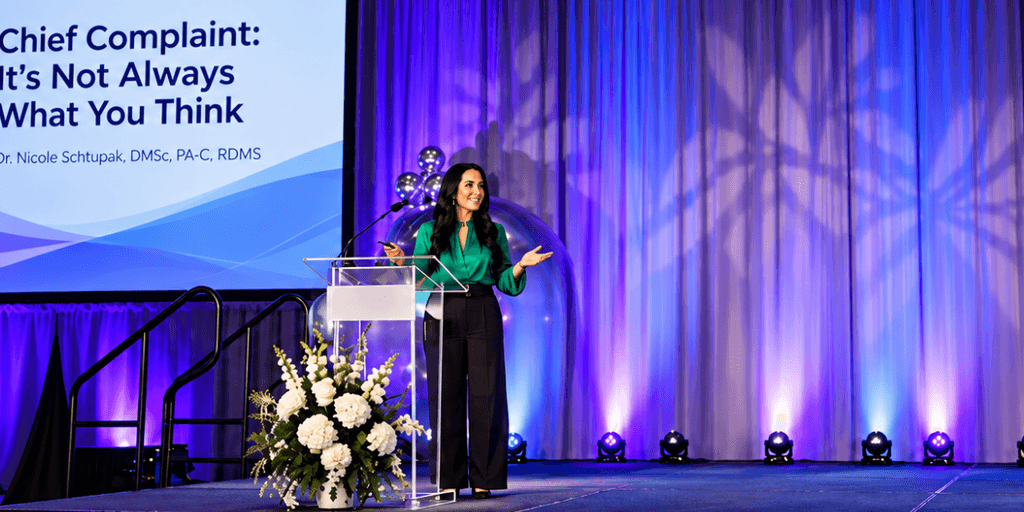 A woman speaking at a podium in front of a presentation screen.