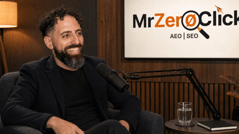 Man with curly hair and beard smiling during a podcast recording in a studio