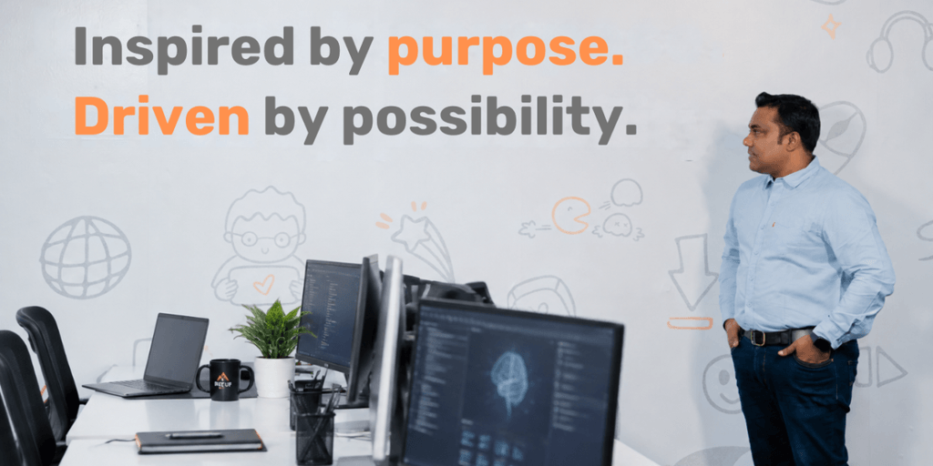 A man stands in an office, reflecting on a motivational poster about purpose and possibility