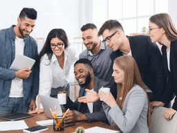 Group of diverse professionals collaborating around a laptop in a modern office setting