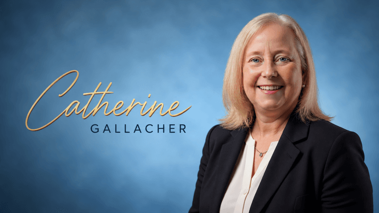 Smiling woman in a blazer with a blue background and her name displayed.