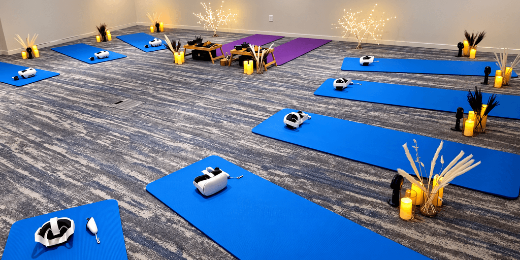 A serene yoga studio with blue mats, VR headsets, candles, and decorative plants