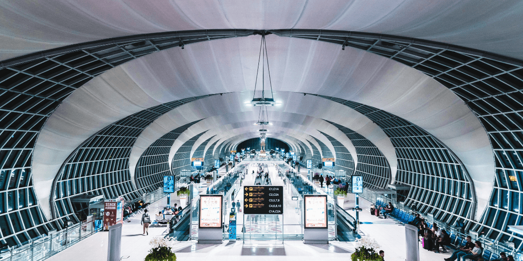 Spacious airport interior with modern architecture and busy passenger flow.