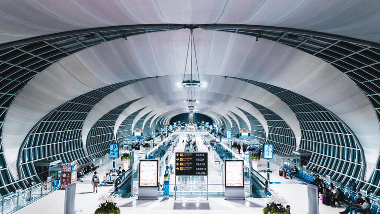 Spacious airport interior with modern architecture and busy passenger flow.