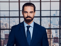 A man in a suit stands confidently against a city skyline backdrop