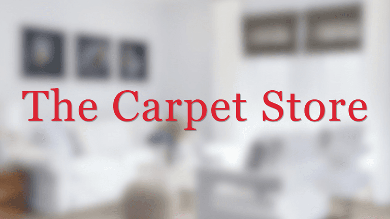 Blurred interior of a living room with the text "The Carpet Store" superimposed