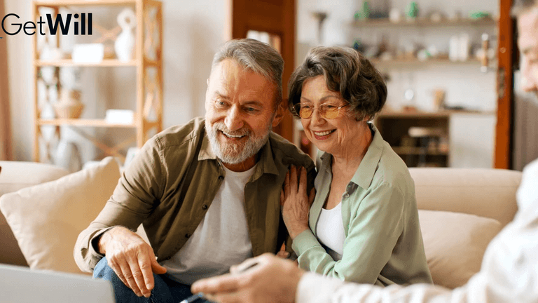Elderly couple smiling together while using a laptop in a cozy living room
