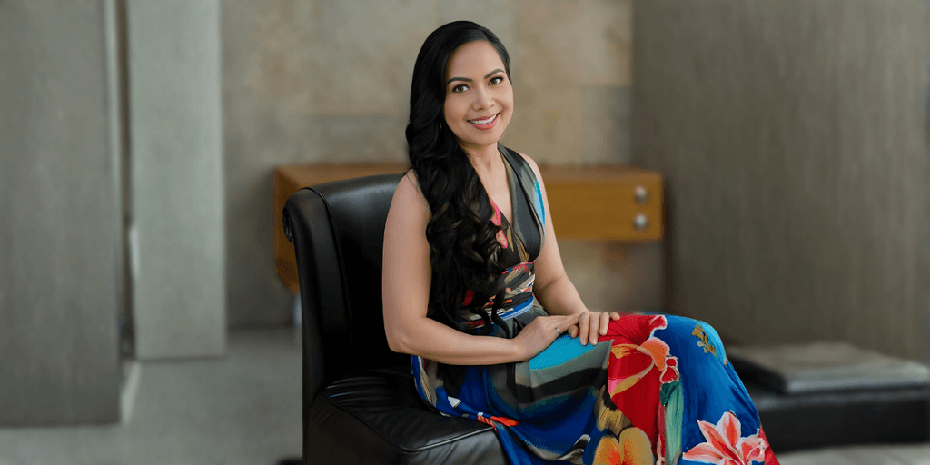 Liza Baliad, founder of Renew by Liz, seated in a vibrant dress, embodying beauty, purpose, and sustainable skincare