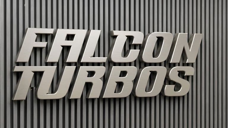 Metallic Falcon Turbos wall logo mounted on vertically ribbed industrial background.