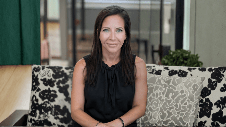 Laurie Groh, founder of Shoreside Therapies, sitting comfortably in a cozy, welcoming therapy space, embodying connection and warmth.