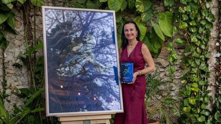 The image features Dra. Katha Jones standing beside a framed artwork, holding her book "Think Outside the Box."