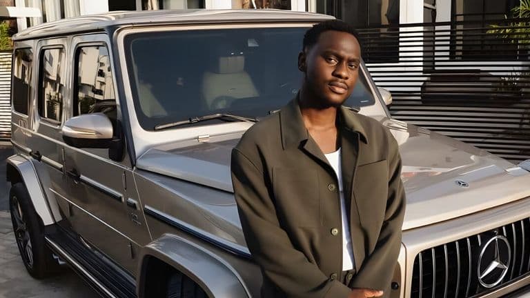A young entrepreneur, Lucky Mane, standing confidently in front of a Mercedes G-Wagon, representing his success in business.
