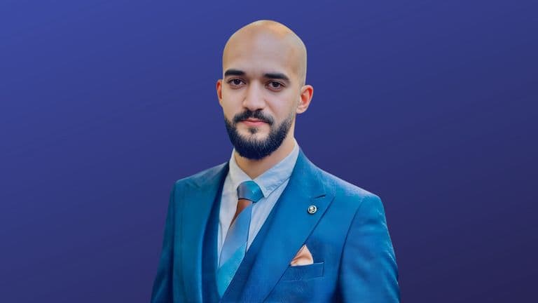 Taher Amine ELHOUARI in a blue suit, embodying leadership in cybersecurity with a strategic, resilient approach.