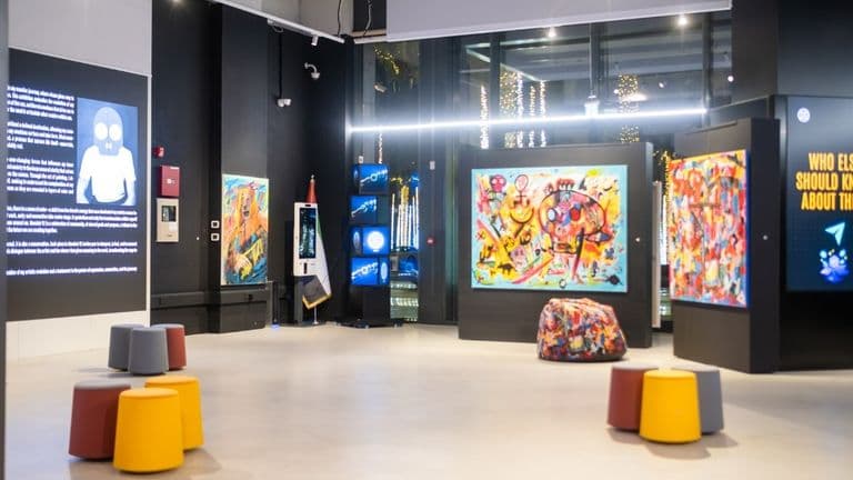 An art gallery space featuring vibrant artworks, digital displays, and modern seating, reflecting Mondoir's cultural vision and ethos.