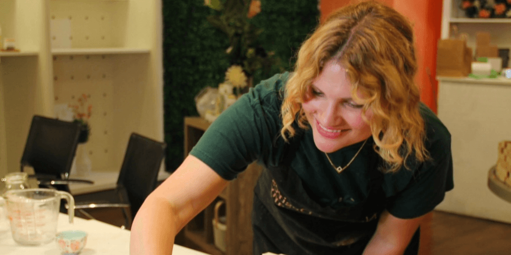 Nicole Boshell, founder of Natural Desires Soap Company, smiling while crafting natural soaps in her workshop, promoting toxin-free skincare.