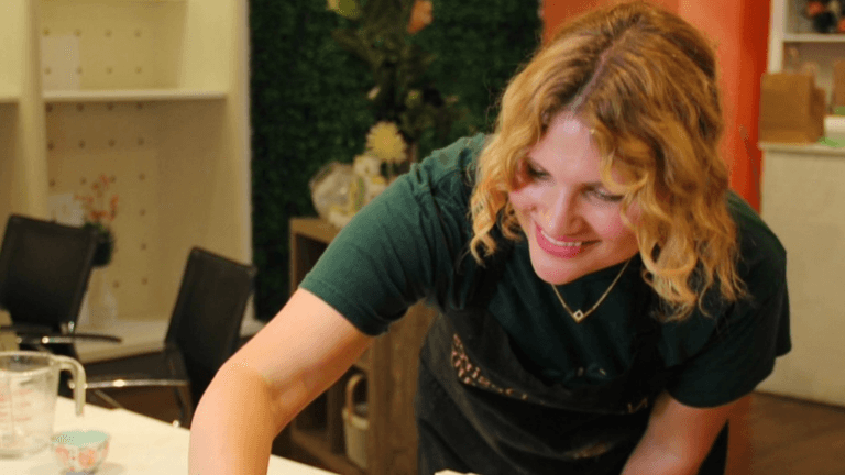Nicole Boshell, founder of Natural Desires Soap Company, smiling while crafting natural soaps in her workshop, promoting toxin-free skincare.