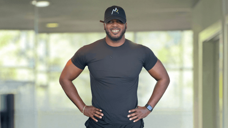 Chaz Ferguson standing confidently, showcasing his fitness and strength, embodying his holistic approach to personal transformation and empowerment.