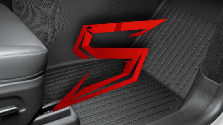 A close-up of a vehicle interior with a red "S" logo on the floor mat, symbolizing CabinProtect™.