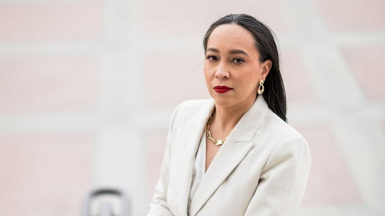 Tina Patterson in a white suit with red lipstick, exuding confidence as she discusses strategic legal counsel for leaders.