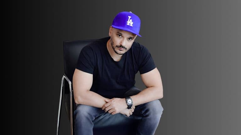 "Imran Nizami, founder of SEOGorillas, sitting confidently in a chair wearing a purple LA cap, showcasing his leadership.