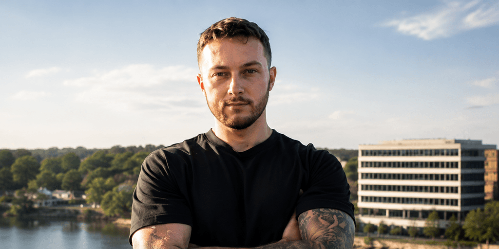 Josh Norris standing outdoors with arms crossed overlooking a city skyline.
