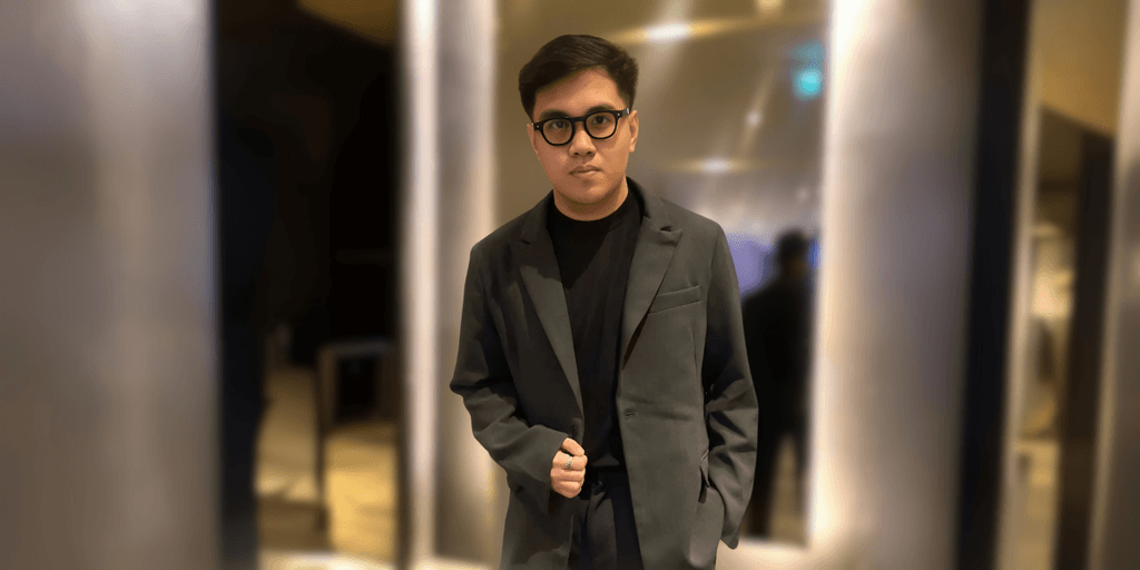 Neil Hernandez in a dark suit, standing confidently indoors, representing AI-driven marketing systems for service businesses.
