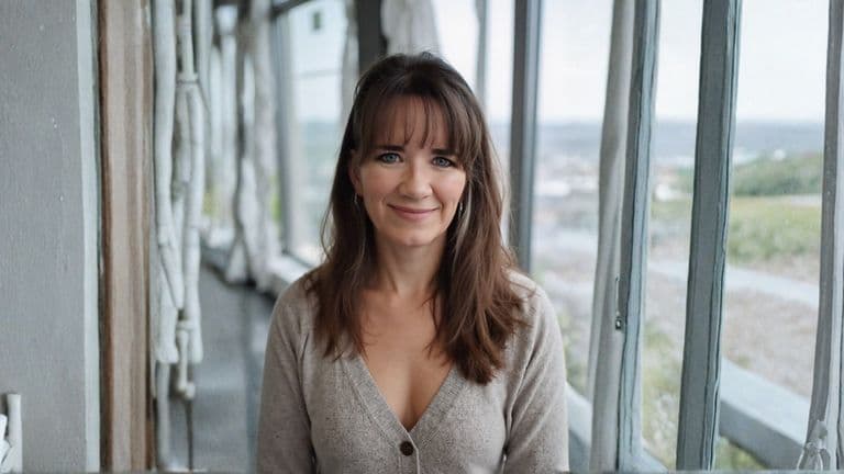 Rebecca Irey, founder of Blue Skye Financial, stands in a bright, airy space, exemplifying clarity and confidence in financial planning.