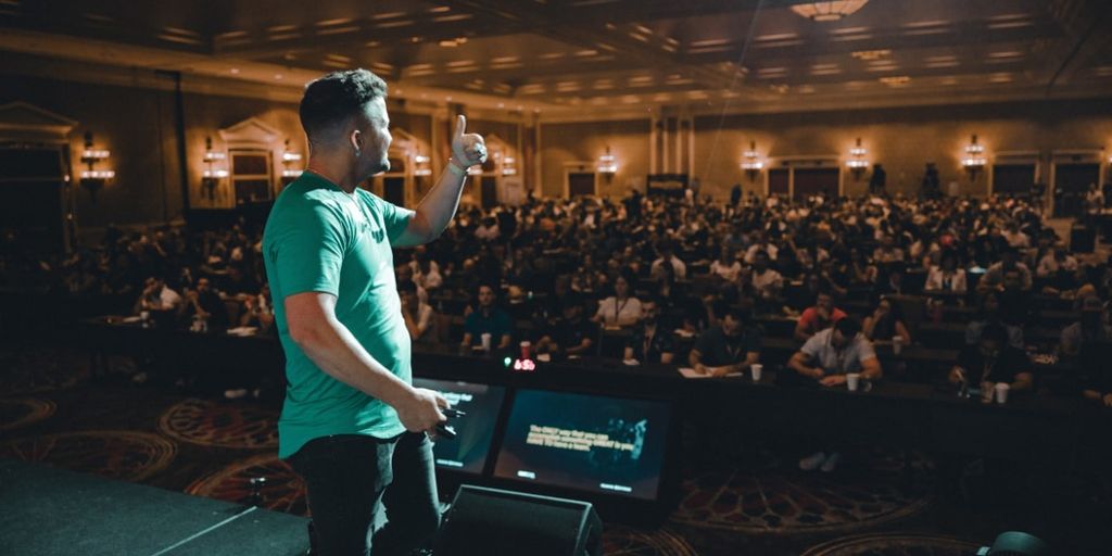 Chris Lee speaking to a large audience at a business event, sharing insights on scaling businesses and leadership.