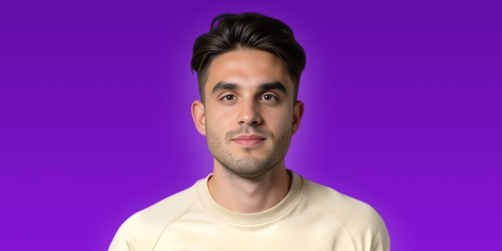A man in a white shirt smiles at the camera, embodying confidence and approachability in a professional setting.