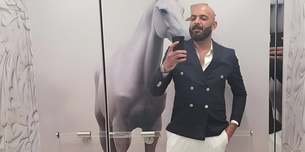 Ehtasham Malik, CEO of Mayfair Group, posing in a luxury setting with a modern suit, reflecting his innovative vision.