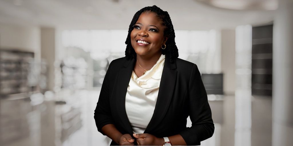 A smiling woman in a business suit, representing innovation in creative technology and entrepreneurship.