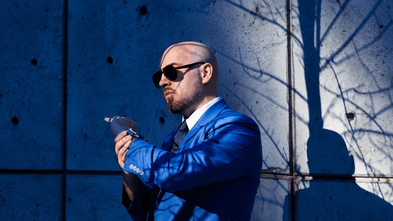 Liam Legault, founder and creative director of Liam Legault Design, wearing a blue suit and sunglasses.