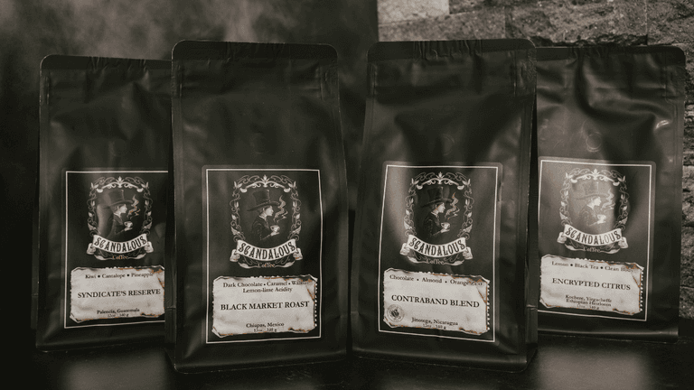 Four Scandalous Coffee bags featuring unique roast names and dark, elegant packaging.