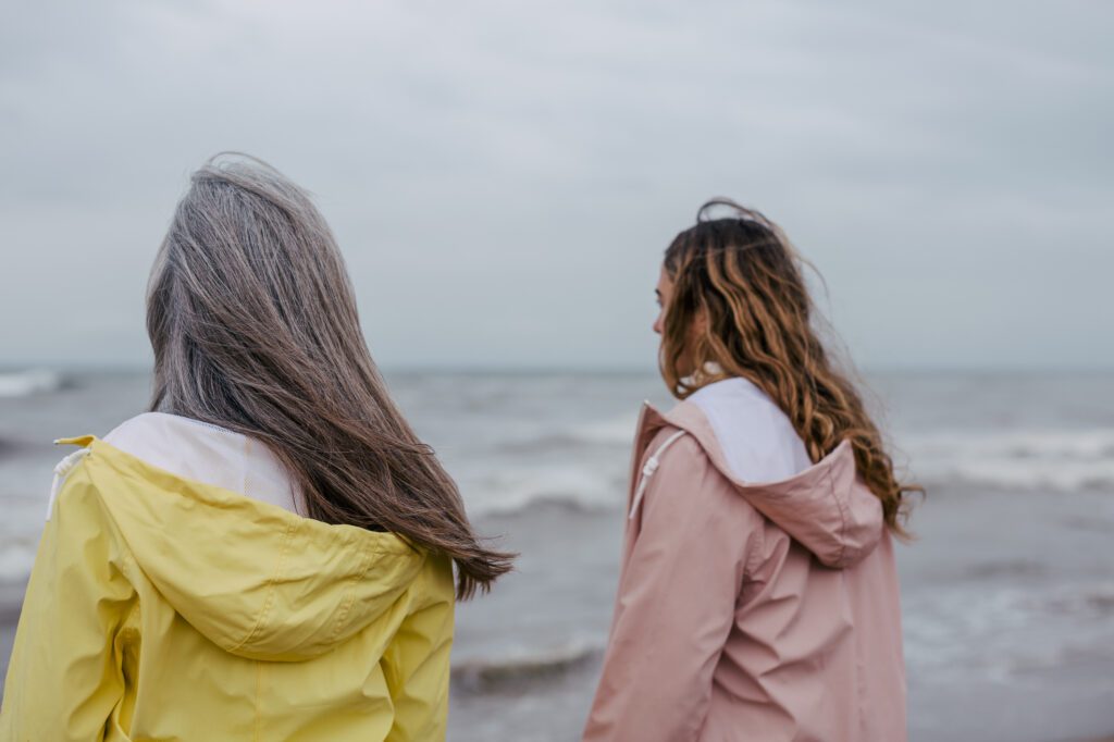 Senior woman and her daughter looking the sea on a winter day.