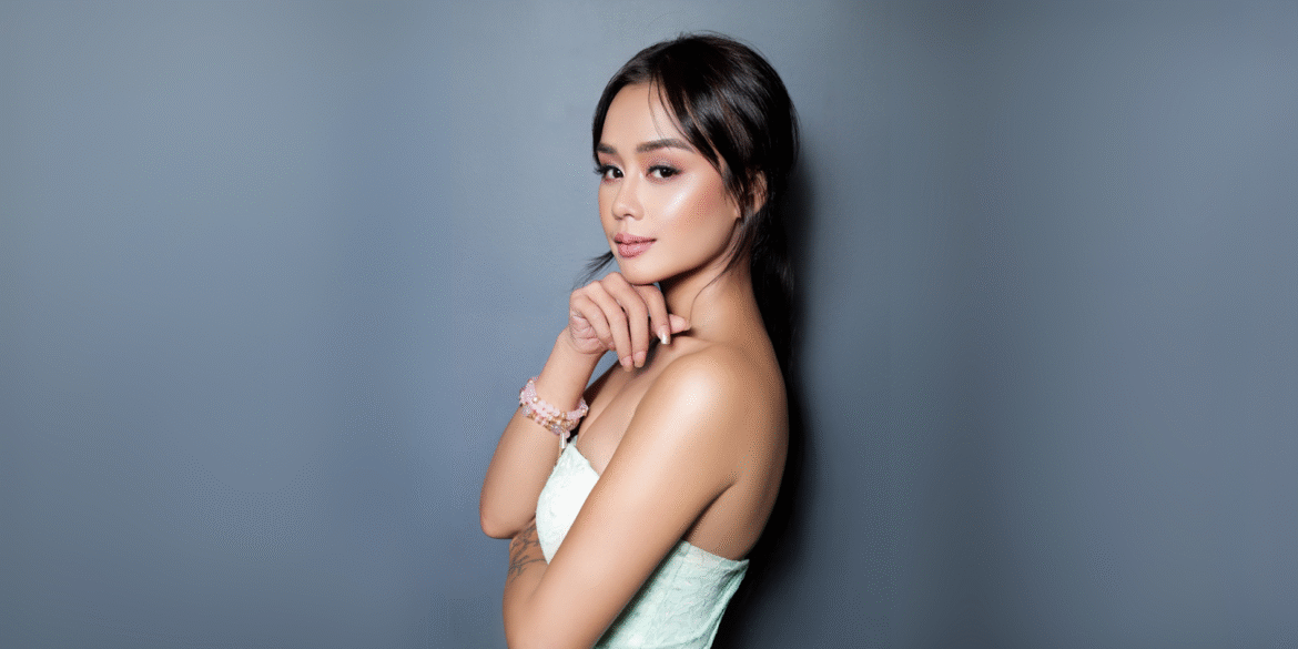 Confident female entrepreneur posing against a sleek gray background, symbolizing the professionalism and high-performance support offered by One Dial Solutions' virtual assistant teams.