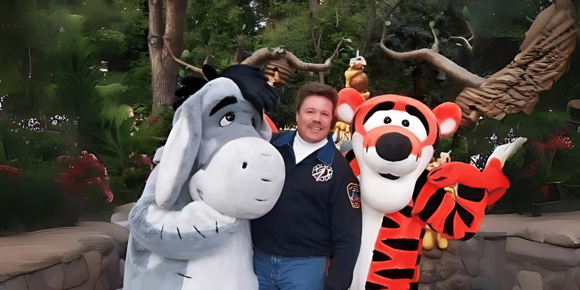 A man posing with Disney characters Eeyore and Tigger at a theme park, symbolizing the creative freedom and community-building spirit of GB-K Productions, a platform supporting independent artists in film, music, and other artistic industries.