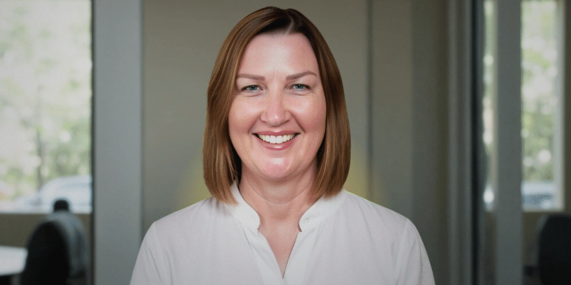 Renee West, founder of Intariq, smiling in front of a blurred office background, advocating for human-centered AI solutions.