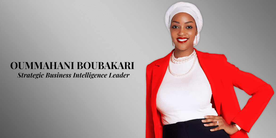 Portrait of Oummhani Boubakari, a Strategic Business Intelligence Leader, wearing a red blazer, white top, and pearl necklace.