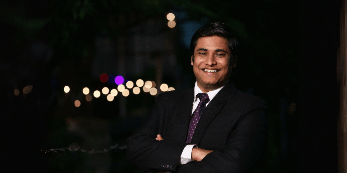 Vivek Rangabhashyam smiling in a suit, representing his inspiring journey of resilience, entrepreneurship, and community impact.