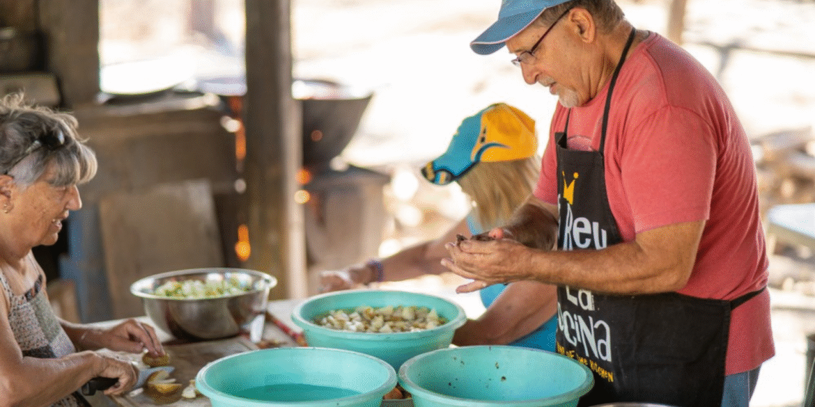 Volunteers preparing food together in an outdoor kitchen at The Monkey Farm community project.